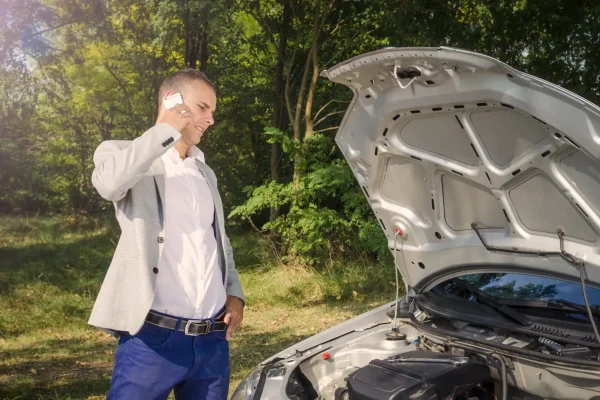man-standing-by-open-hood-making-phone-call-trying-fix-vehicle